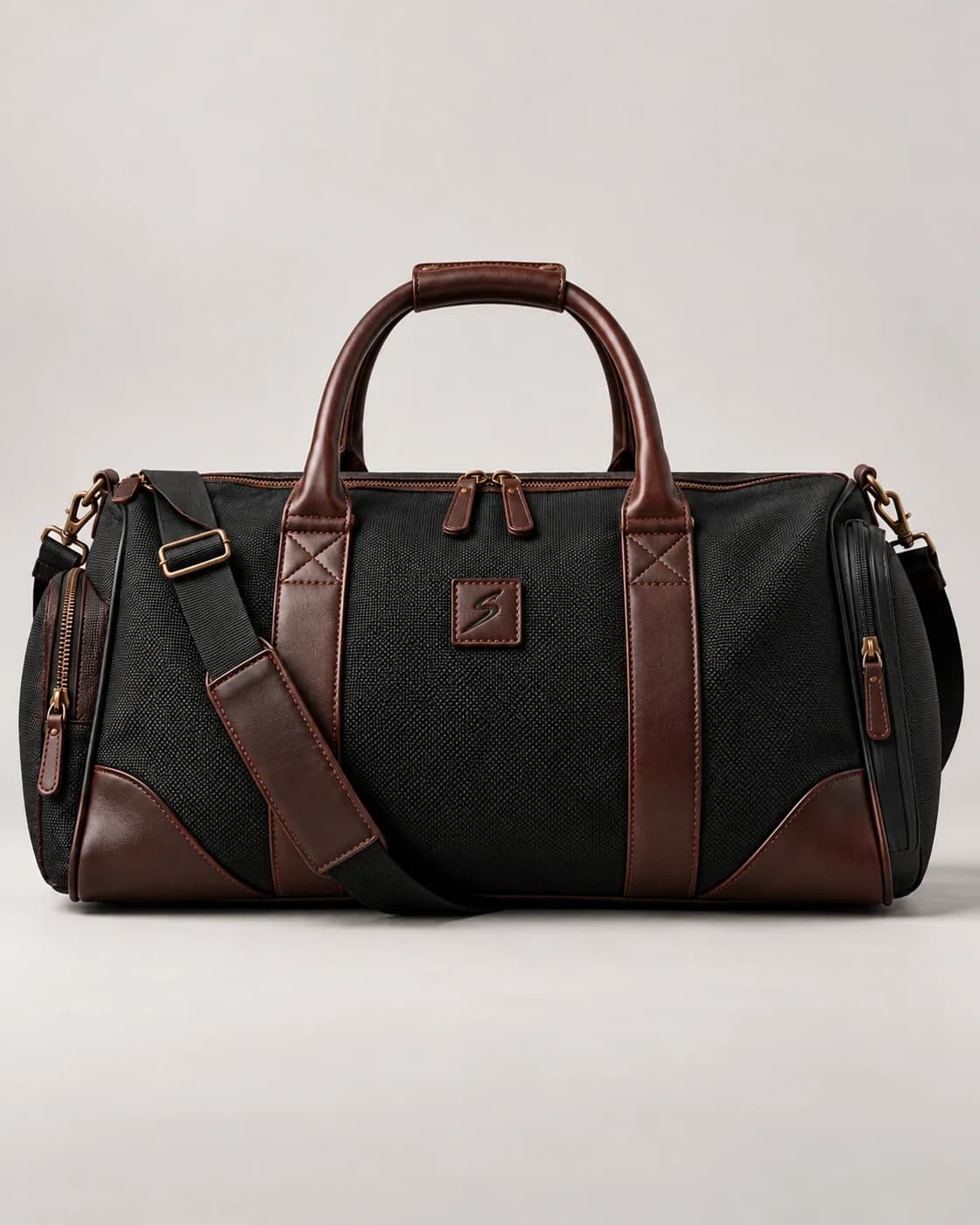 Leather-trim gym duffel in black canvas with brown leather and S patch